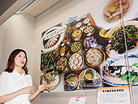 113shokubunka 展示パネルの前で食文化について説明する楊さん